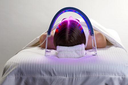 Woman using facial acupuncture and LED light therapy