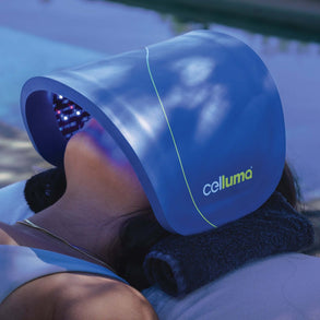 Woman using a Celluma FACE LED light therapy device for facial skin treatment