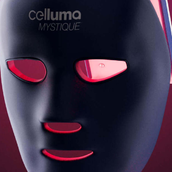 Celluma MYSTIQUE mask turned on and tilted slightly forward and floating above a flat surface.
