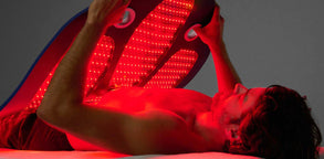 Young man placing the Celluma DELUX over his body like a weighted blanket.