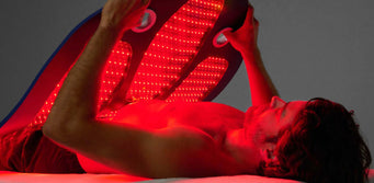 Young man placing the Celluma DELUX over his body like a weighted blanket.