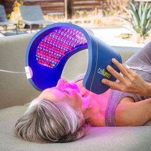 Women laying on the couch using the Celluma PRO over the face for treating aging skin with red light therapy.