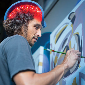 Man using the RESTORE over the head while painting.